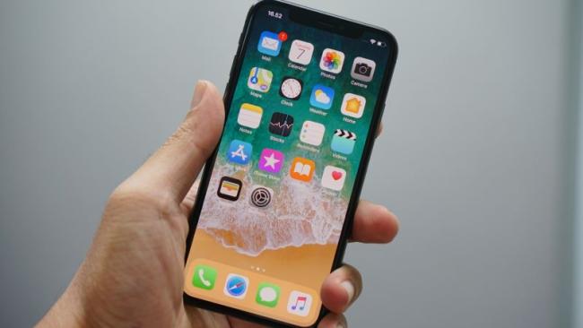 iPhone s domovskou obrazovkou iOS na displeji