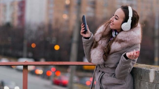 Žena poslouchá hudbu ze smartphonu v chladném dnu