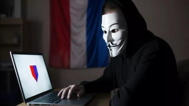 Hacker s počítačem, maska anonymous